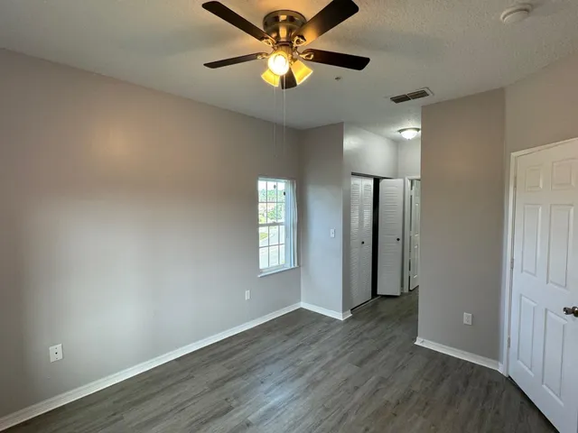a view of empty room with window and wooden floor