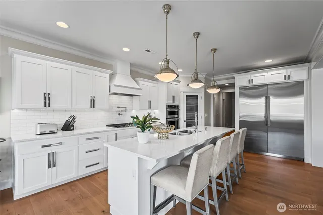 a kitchen with stainless steel appliances kitchen island granite countertop a table chairs and white cabinets