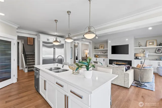 a kitchen with stainless steel appliances kitchen island granite countertop a sink a stove and a wooden floor