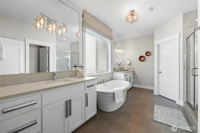 a spacious bathroom with a double vanity sink mirror and bathtub