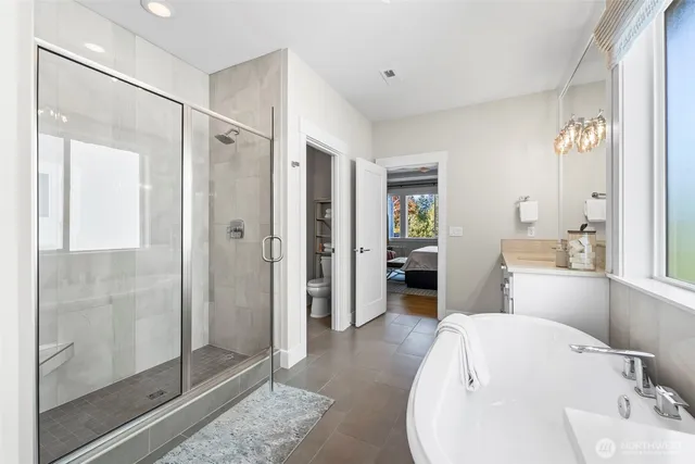 a bathroom with a tub sink shower and mirror