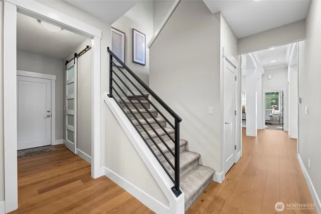 a view of a hallway with wooden floor and staircase