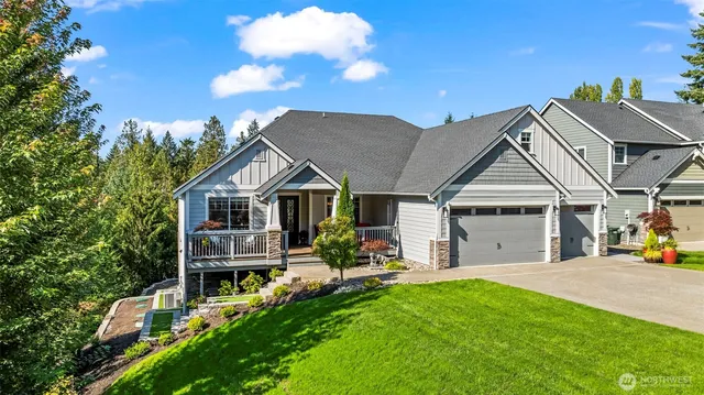 a view of a white house with a small yard and large trees