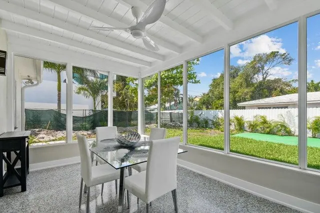 a dining room with large glass windows and wooden floor