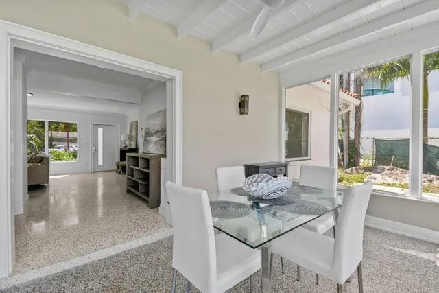 a dining room with furniture and a floor to ceiling window