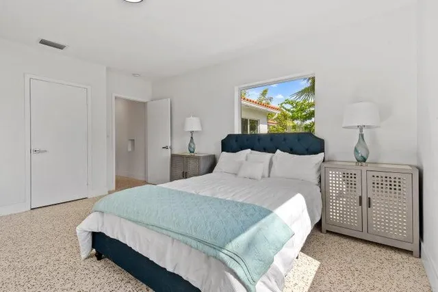 a bedroom with a bed and a painting on the wall