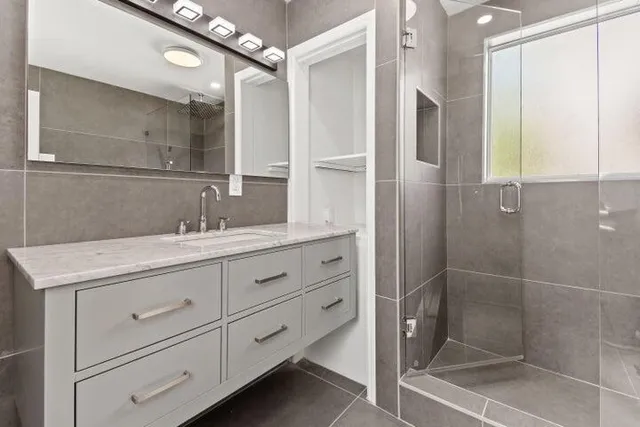 a bathroom with a shower sink and mirror