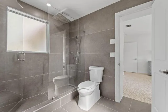 a bathroom with a toilet and a shower