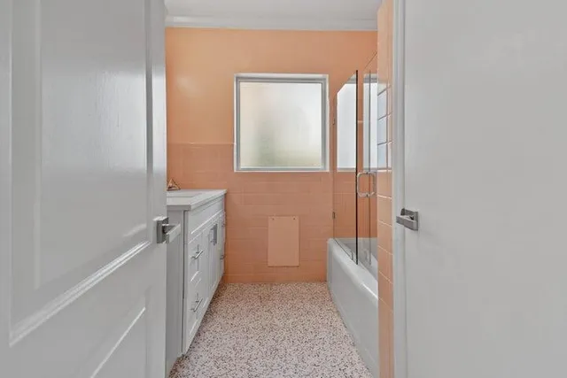 a bathroom with a bathtub sink and mirror