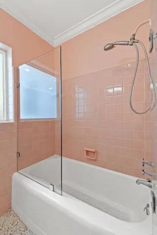 a bathroom with a white bath tub sitting next to shower