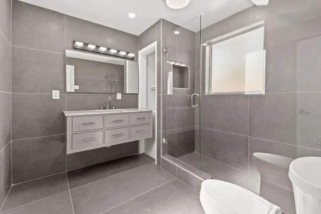 a bathroom with a toilet a sink and glass door