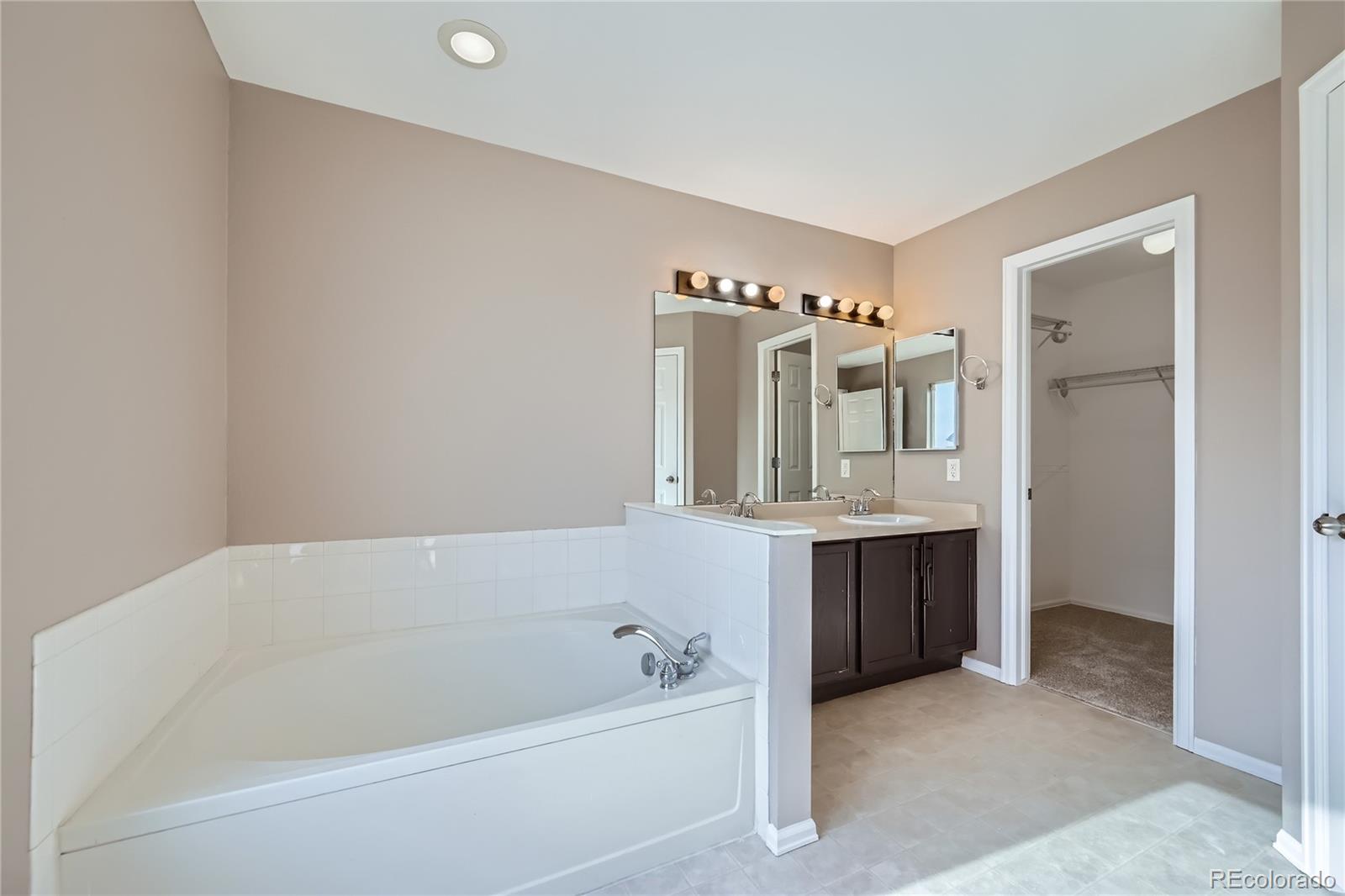 4296 Clover Lane Brighton, CO 80601 - Photo 19 of 35 a bathroom with a tub sink and mirror