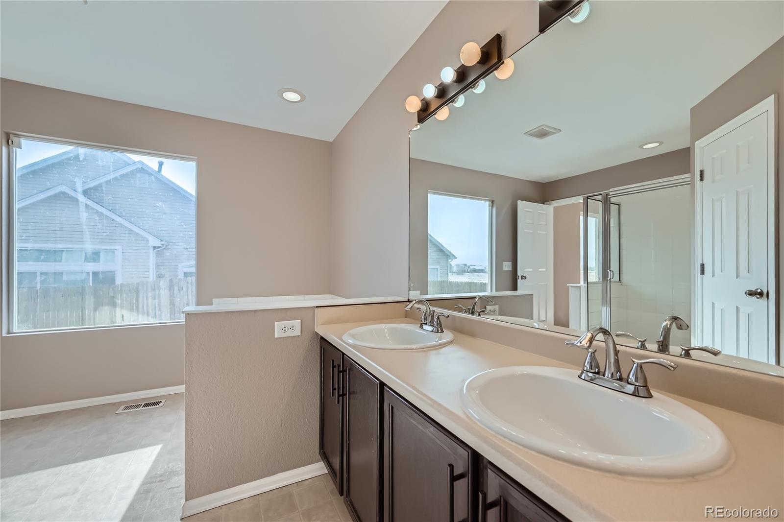 4296 Clover Lane Brighton, CO 80601 - Photo 21 of 35 a bathroom with a double vanity sink and a mirror