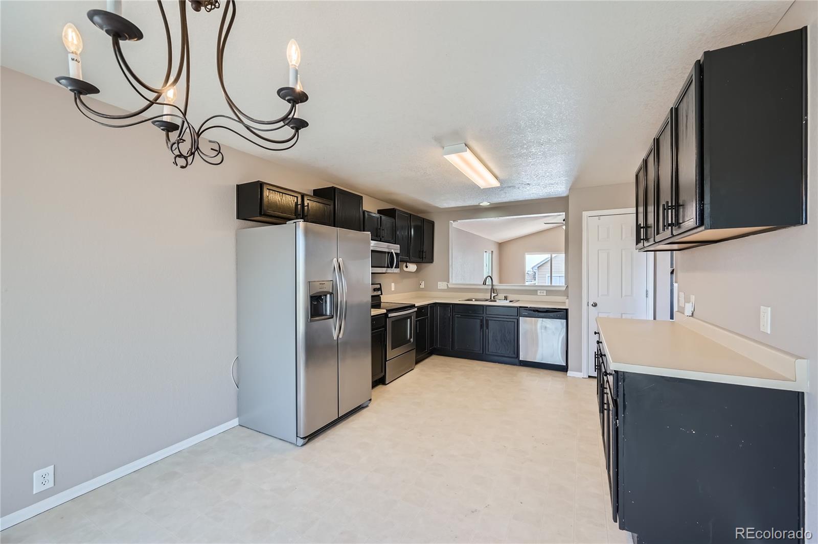 4296 Clover Lane Brighton, CO 80601 - Photo 9 of 35 a kitchen with stainless steel appliances a refrigerator and a sink