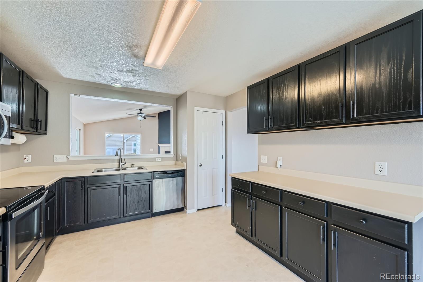 4296 Clover Lane Brighton, CO 80601 - Photo 10 of 35 a large kitchen with cabinets and stainless steel appliances