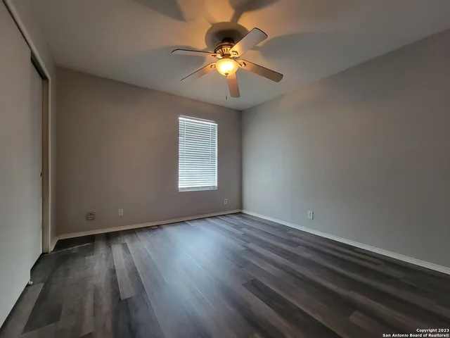 a view of an empty room with wooden floor