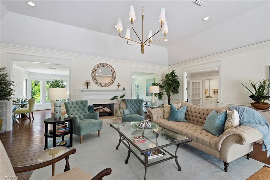 2700 Treasure Lane Naples, FL 34102 - Photo 11 of 44 a living room with furniture a rug and a chandelier