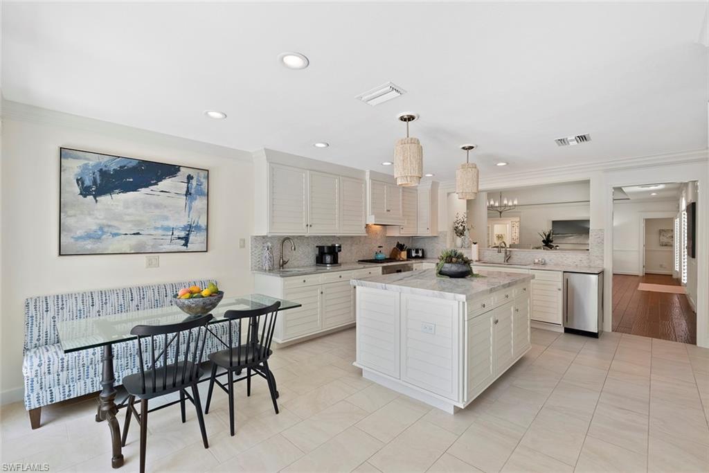 2700 Treasure Lane Naples, FL 34102 - Photo 12 of 44 a kitchen with stainless steel appliances granite countertop a table chairs and a refrigerator