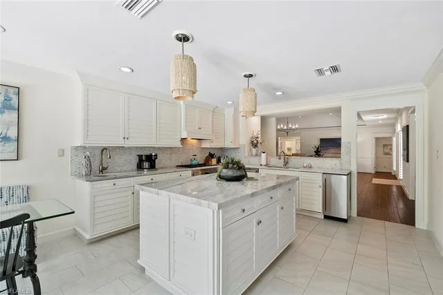 a kitchen with a sink white cabinets and stainless steel appliances