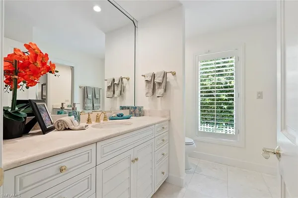 a bathroom with a sink mirror and a window