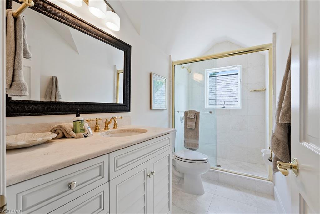2700 Treasure Lane Naples, FL 34102 - Photo 32 of 44 a bathroom with a granite countertop sink a toilet and a mirror