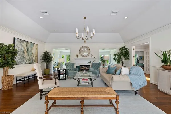 a living room with furniture a chandelier a rug and a chandelier