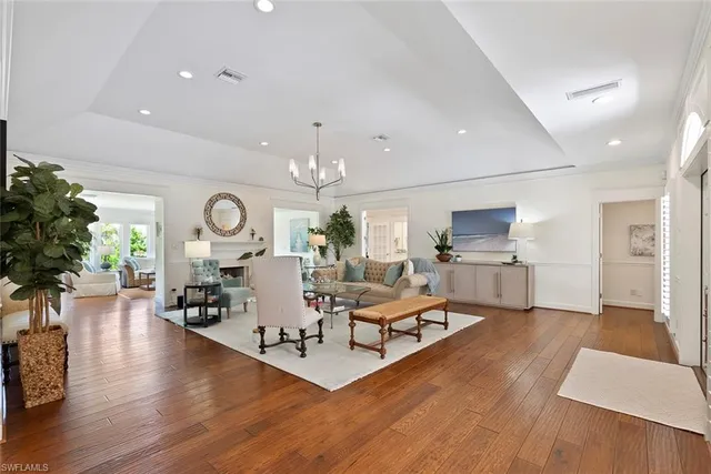 a living room with furniture kitchen view and a wooden floor