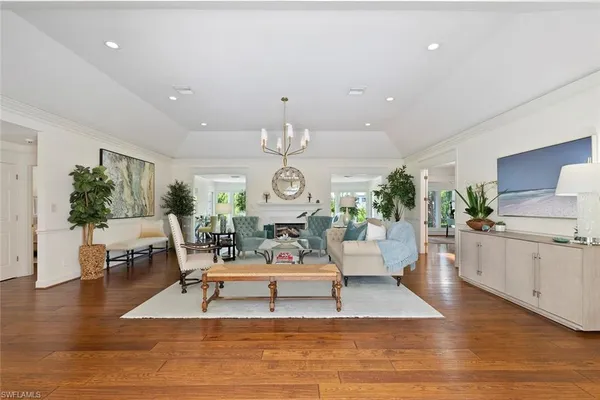 a living room with furniture or chandelier and a wooden floor