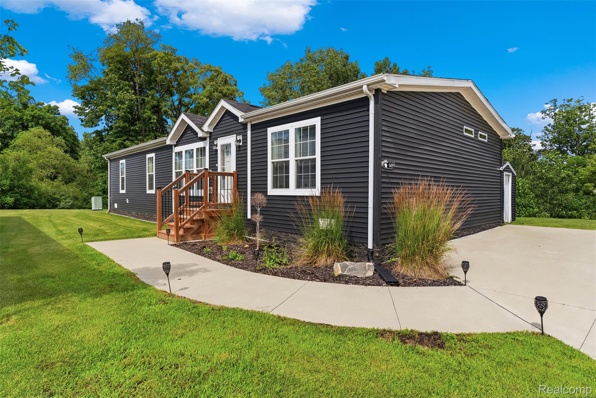 6450 Prince Boulevard Fenton, MI 48430 - Photo 1 of 31 Modern residence with dark siding, crisp white trim, and a concrete pathway