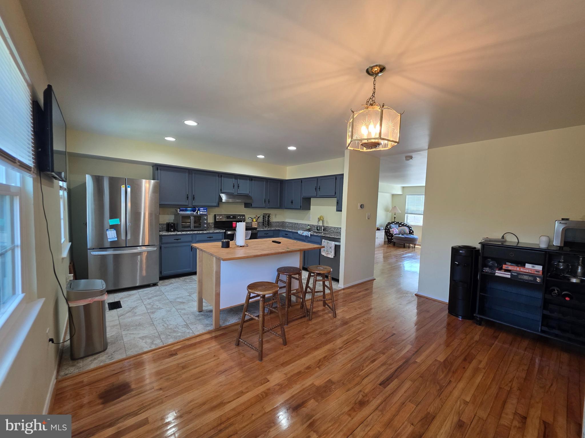 10 Casey Court Baltimore, MD 21228 - Photo 18 of 28 a kitchen with stainless steel appliances granite countertop a refrigerator dining table and chairs with wooden floor