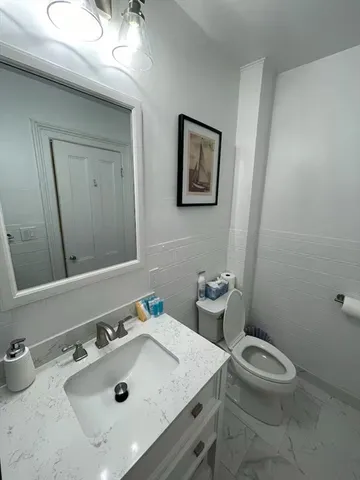 a bathroom with a sink a toilet and mirror