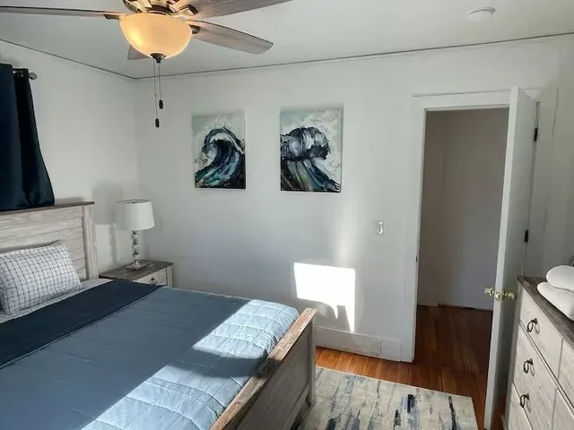 a bedroom with a bed and wooden floor