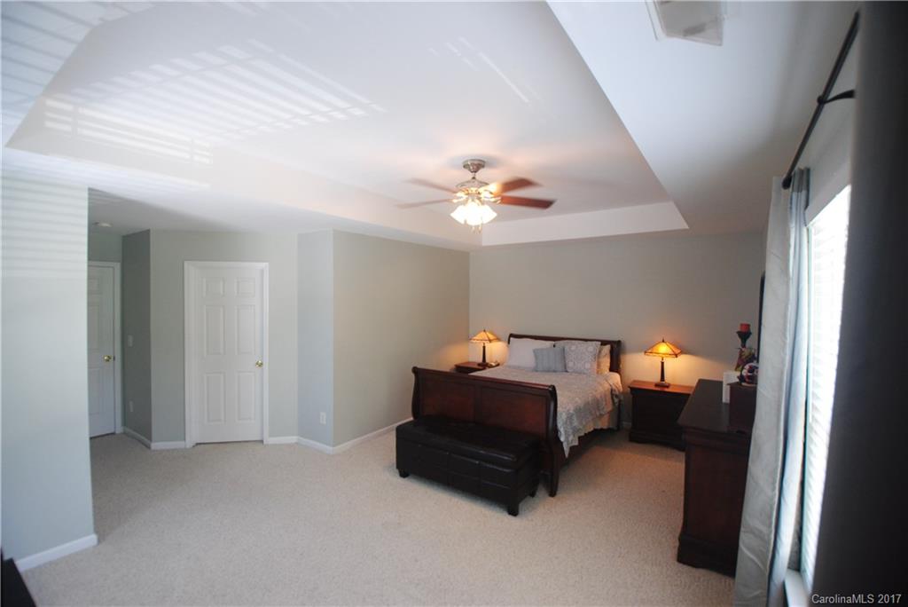 9834 Bailey Road Cornelius, NC 28031 - Photo 15 of 23 a room with a bed and a chandelier