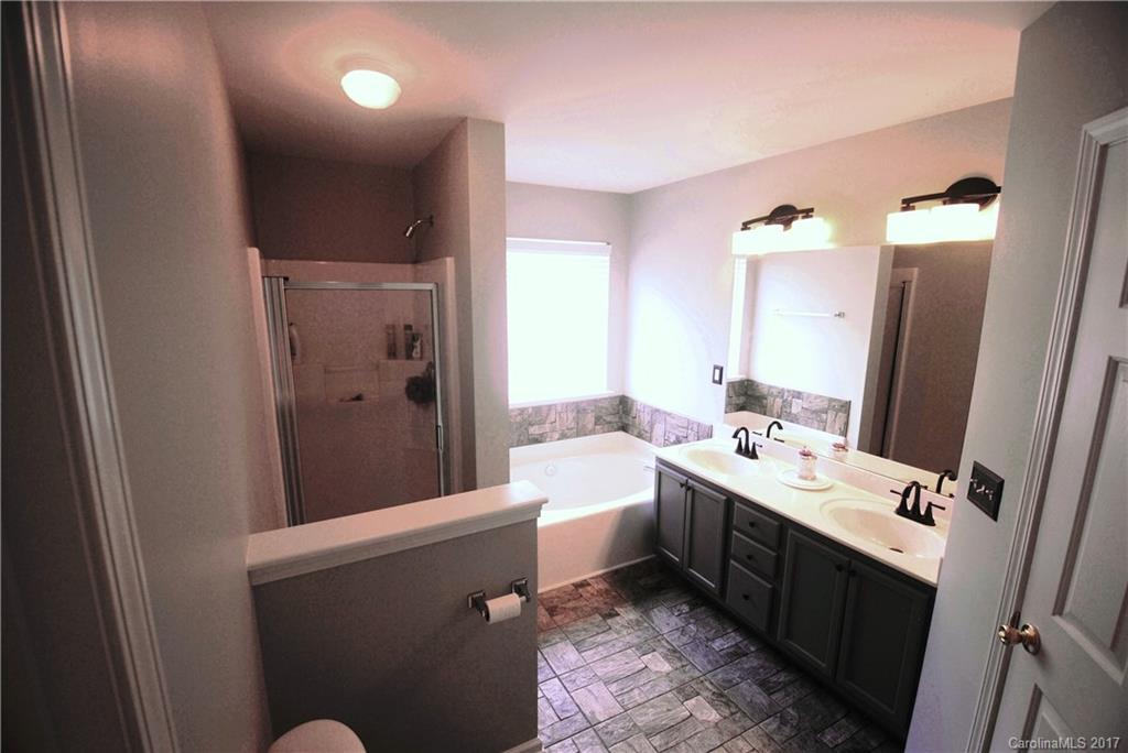 9834 Bailey Road Cornelius, NC 28031 - Photo 16 of 23 a en suite bathroom with a double vanity sink a mirror and a shower