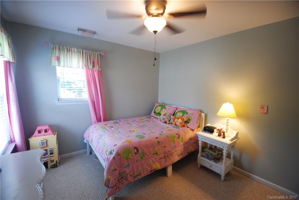 9834 Bailey Road Cornelius, NC 28031 - Photo 18 of 23 a bedroom with a bed and a chandelier