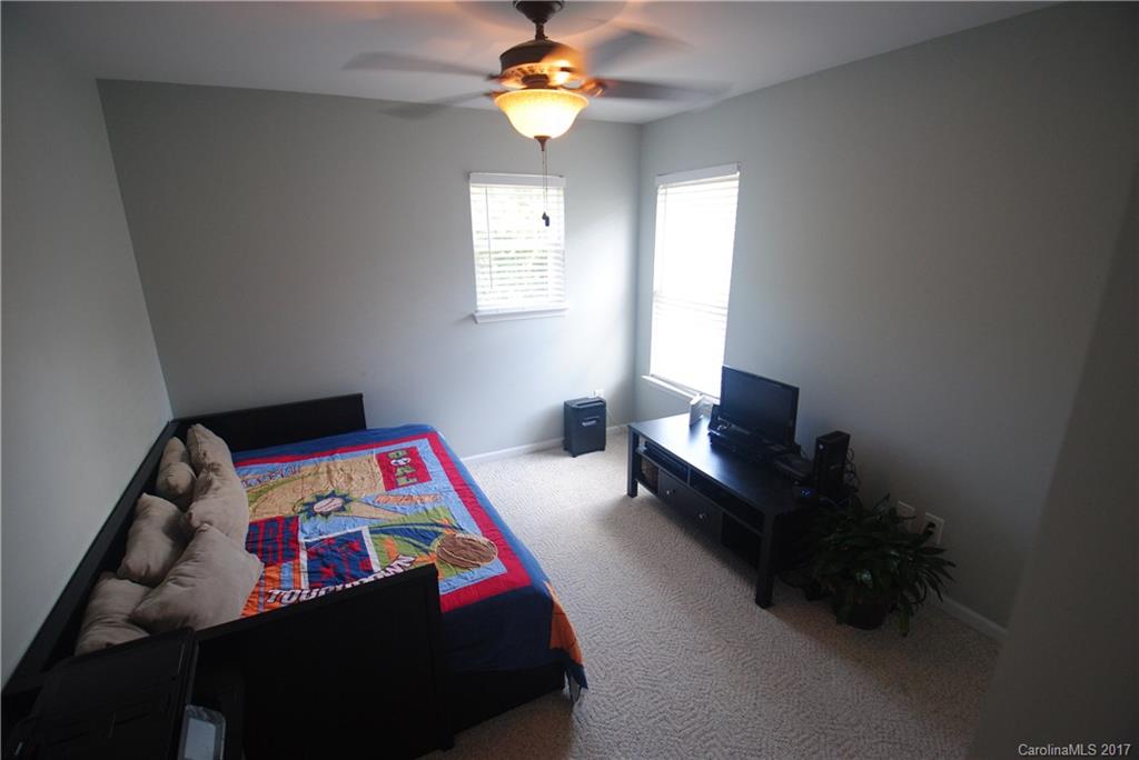9834 Bailey Road Cornelius, NC 28031 - Photo 19 of 23 a bedroom with a bed and a chandelier