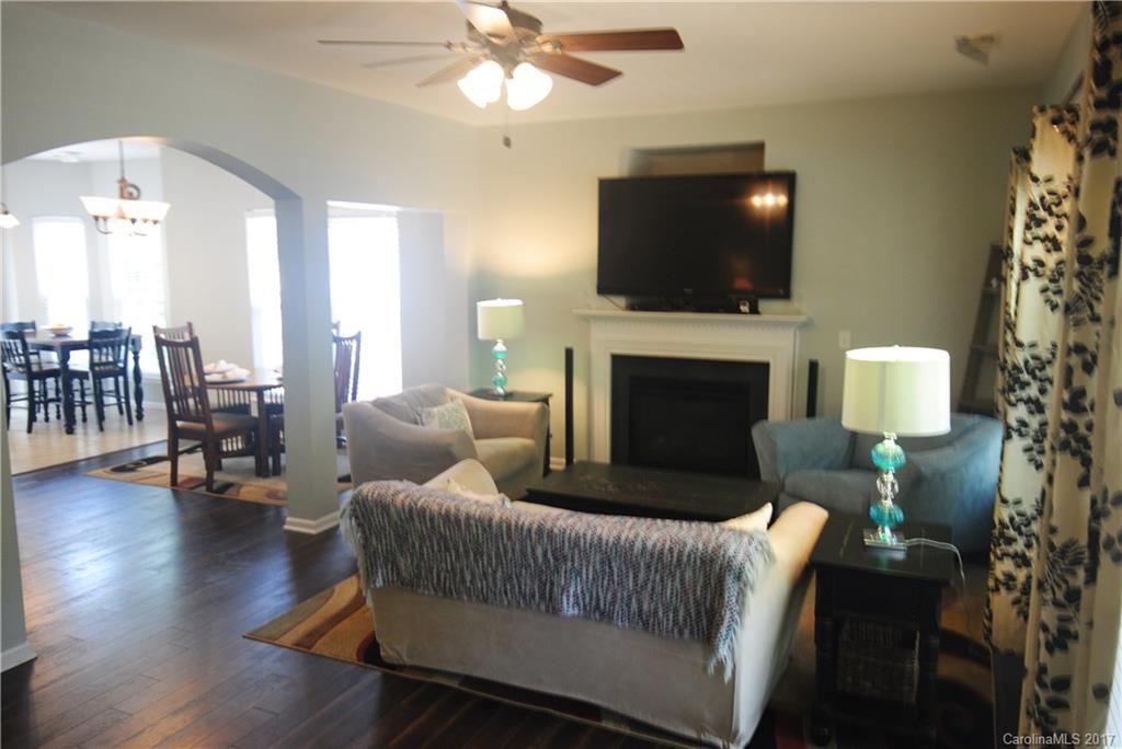 9834 Bailey Road Cornelius, NC 28031 - Photo 5 of 23 a living room with furniture a flat screen tv and a fireplace