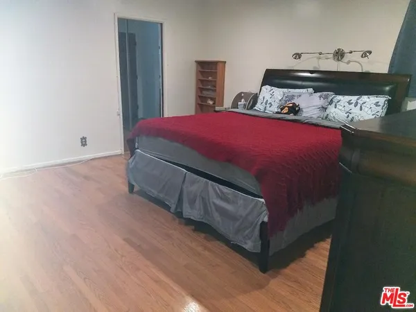 a bed sitting in a bedroom next to a cabinet