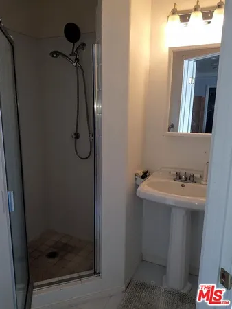 a bathroom with a shower sink and mirror