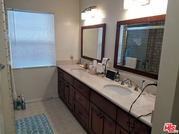 a bathroom with double sink and a mirror