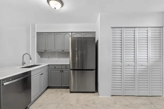 a kitchen with stainless steel appliances granite countertop a refrigerator and a sink
