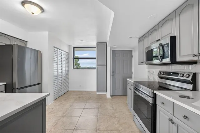 a kitchen with stainless steel appliances granite countertop a refrigerator and a stove top oven