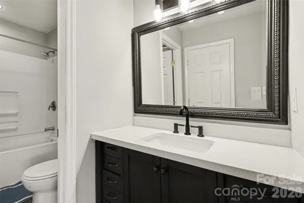 a bathroom with a sink a toilet and a large mirror