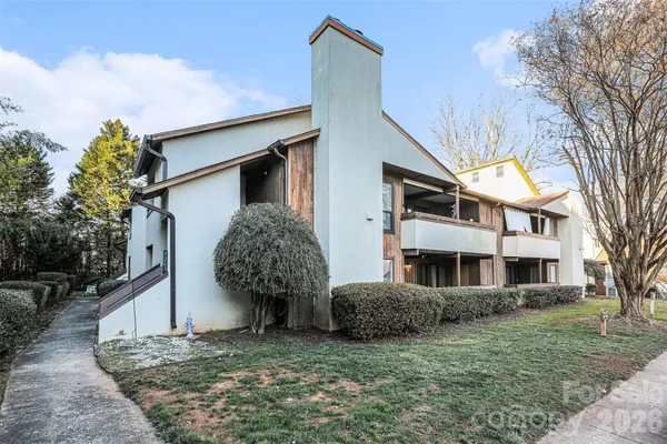 a view of a house with a yard and large tree