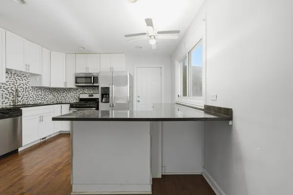 a kitchen with stainless steel appliances a sink stove and cabinets