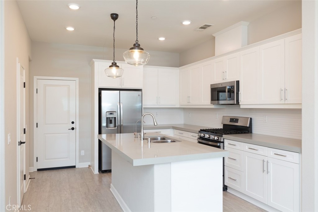 1095 Delpy View Vista Vista, CA 92084 - Photo 1 of 30 a kitchen with kitchen island a sink stainless steel appliances and cabinets
