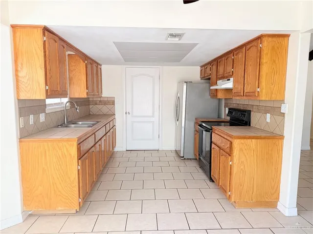 a kitchen with stainless steel appliances a refrigerator and a sink