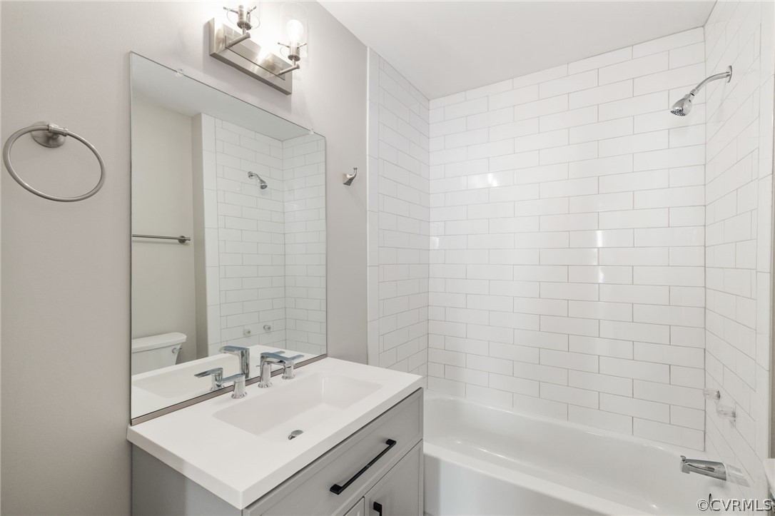 5205 Blue Ridge Avenue Richmond, VA 23231 - Photo 15 of 30 a bathroom with a sink a mirror a bathtub and shower