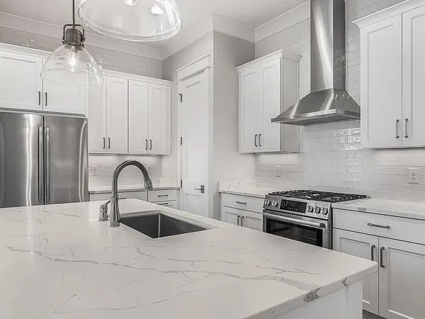 a kitchen with stainless steel appliances a stove a sink a refrigerator and cabinets
