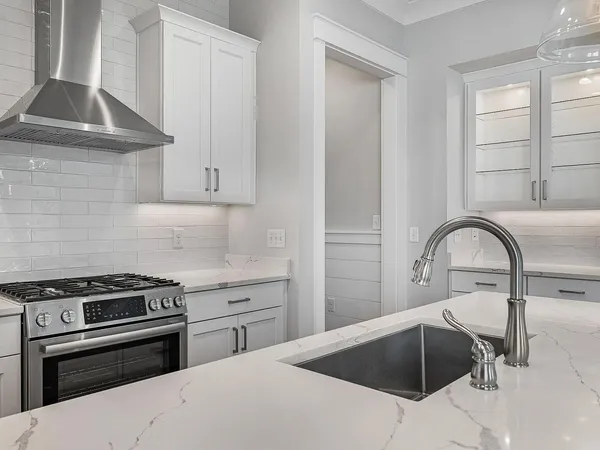 a kitchen with a sink a stove and cabinets